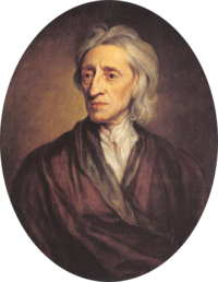 Half-length portrait of a man with a shock of neck-length white hair who is wearing a loose brown robe and white shirt.