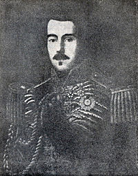 Lithograph depicting a dark-haired man with moustache wearing a heavily embroidered military tunic with epaulettes, sash of office and several medals and orders at his neck