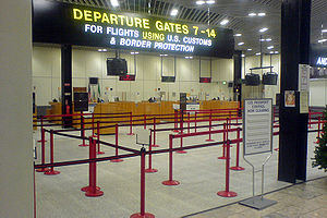 A row of desks beneath a large sign reading "For flights using U.S. customs and border protection".