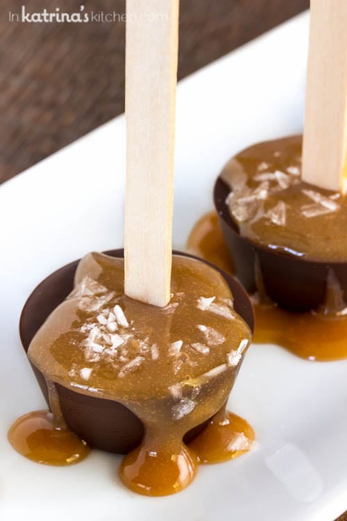 Salted caramel dripping over a chocolate disc with a popsicle stick 