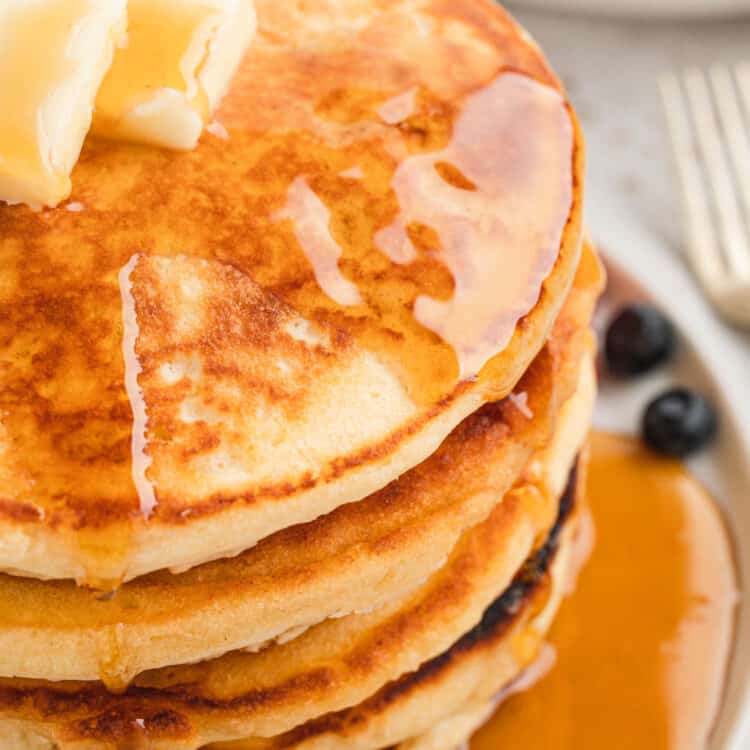 Homemade Pancakes stacked on plate with butter and syrup