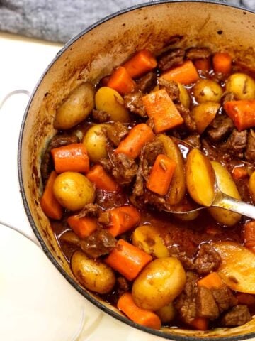 old fashioned beef stew in pot with spoon in a closeup view