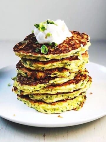 zucchini pancakes stacked up on plate