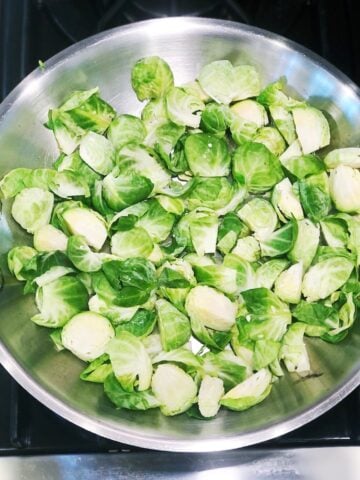 Cleaned and prepared Brussels sprouts in a pan on the stove.