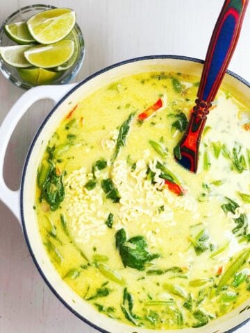 coconut curry soup in a large pot with a spoon.