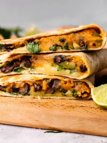 Black bean and sweet potato quesadillas, cut, on a wooden board.