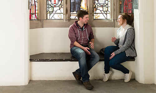 Students sat chatting beneath stained glass window