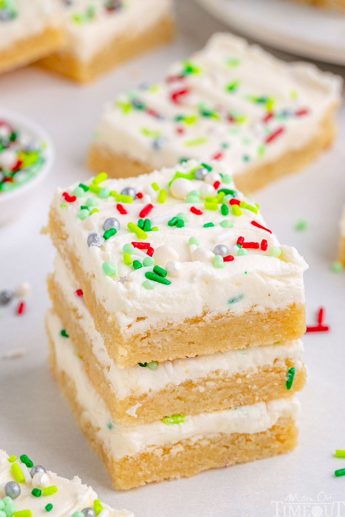 3 Sugar Cookie Bars in a stack with more bars in the background.