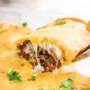 Closeup of a serving of taco bake with cheese oozing out the side.