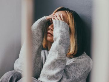 Sad young woman with hands over face