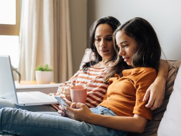 Single mother working from home with preteen daughter around