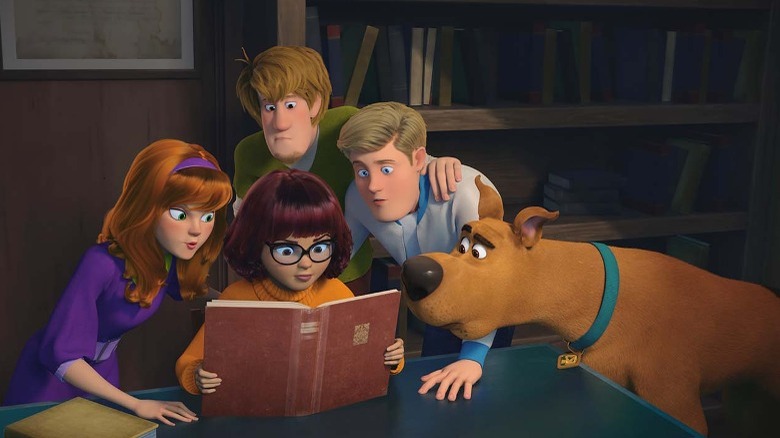 Mystery Inc. huddled around a book