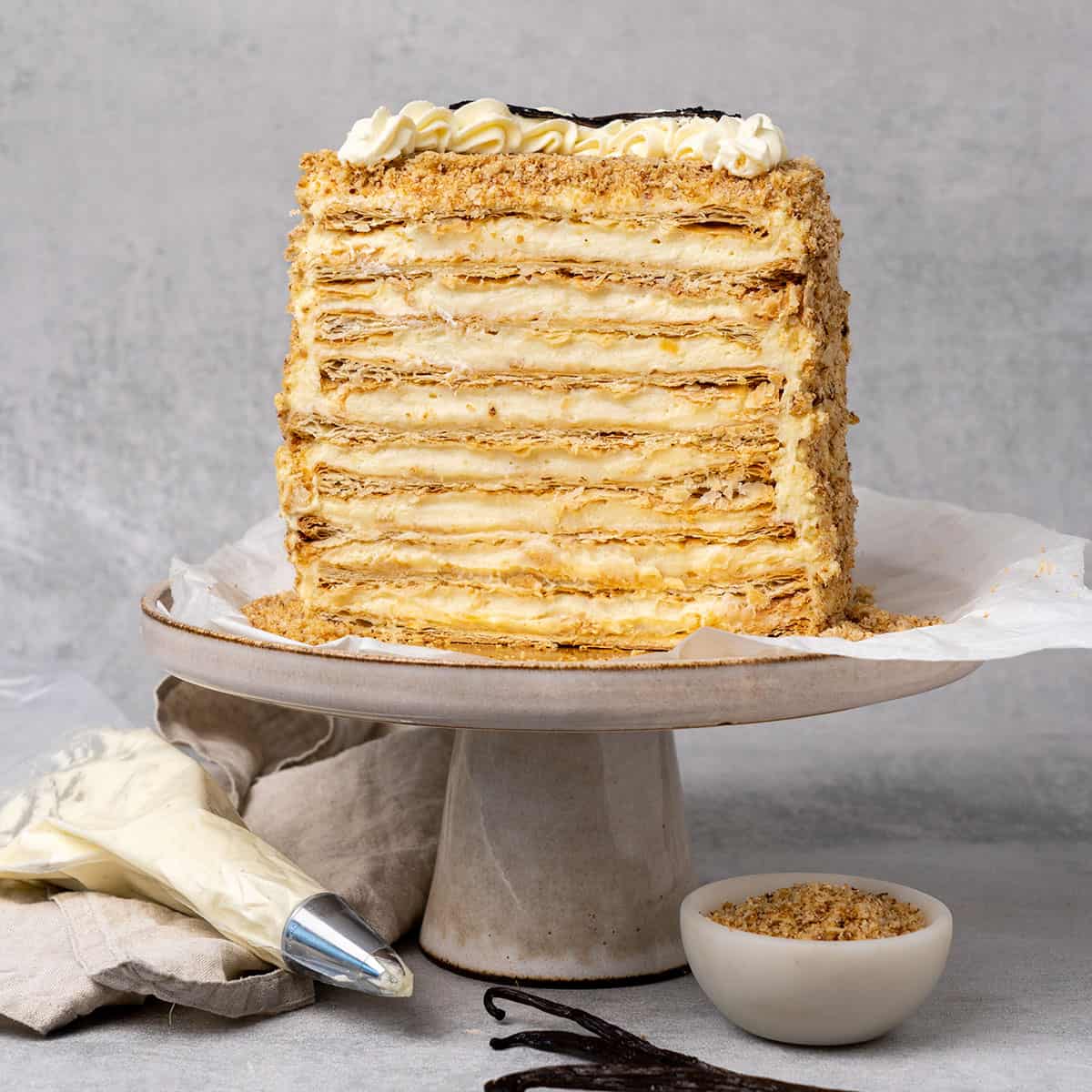 Napoleon cake cut in half on a cake stand.