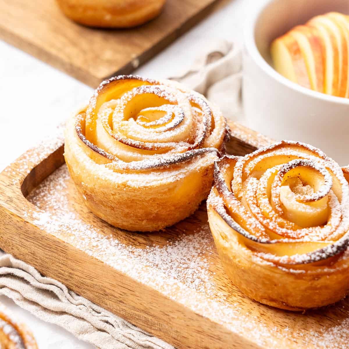 apple roses with puff pastry on a wooden tray.