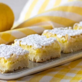 Dessert squares on a plate surrounded by a couple lemons.