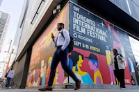 Pedestrians walk past a TIFF sign a day before the Toronto International Film Festival (TIFF) returns for its 49th edition in Toronto, September 4, 2024.