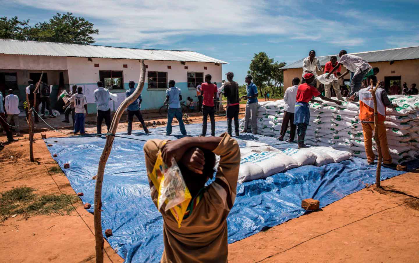 Volunteers help distribute meal bags in Zambia during a severe drought.