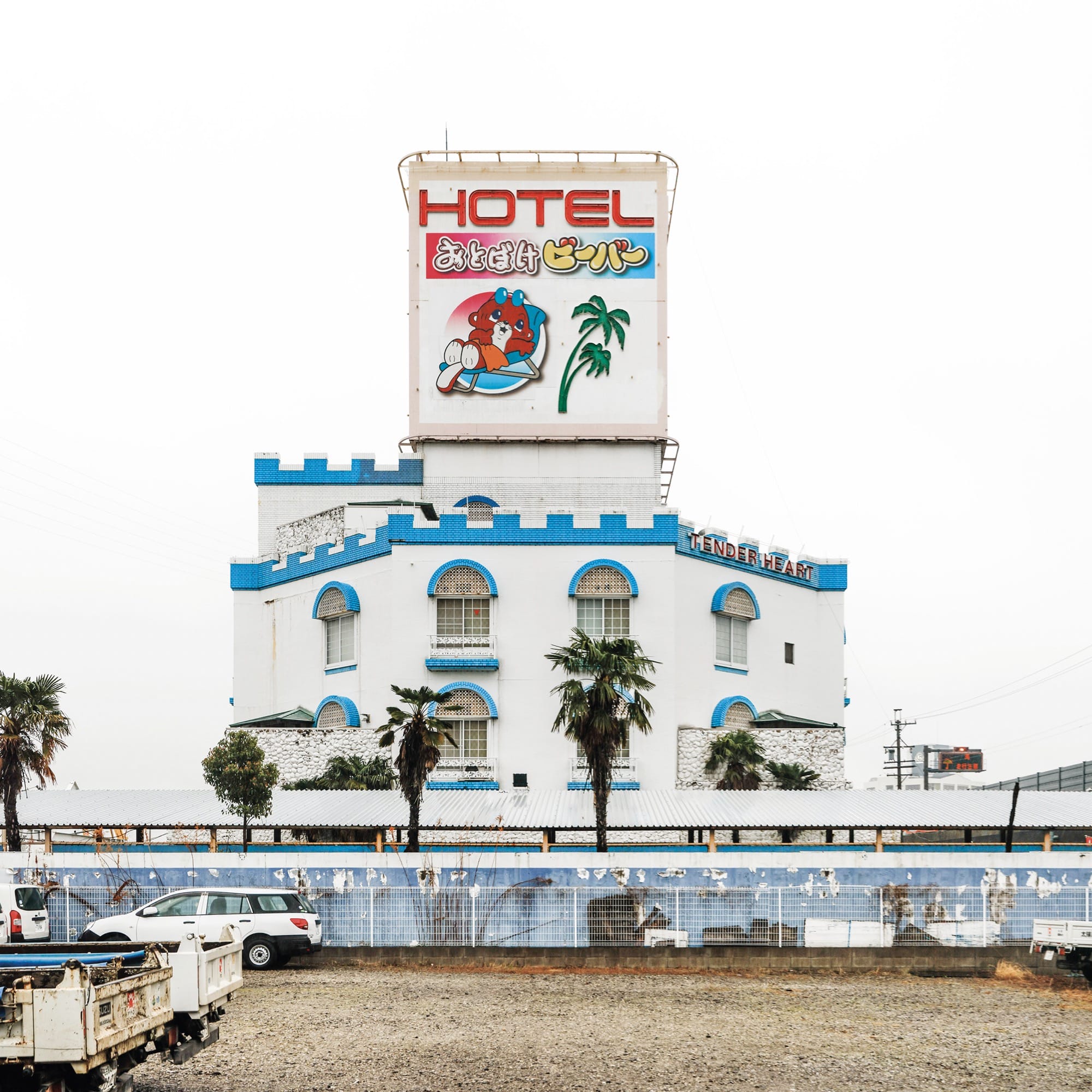 a bright white and blue facade of a castle-themed love hotel in Japan along the roadside