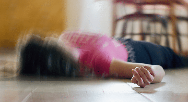 Woman appearing to have a seizure on the floor