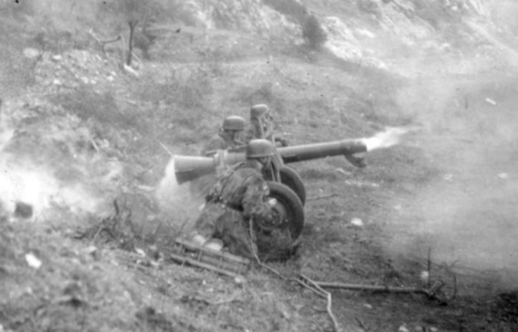 Two German soldiers firing a 10.5 cm Leichtgeschütz 40 in the field