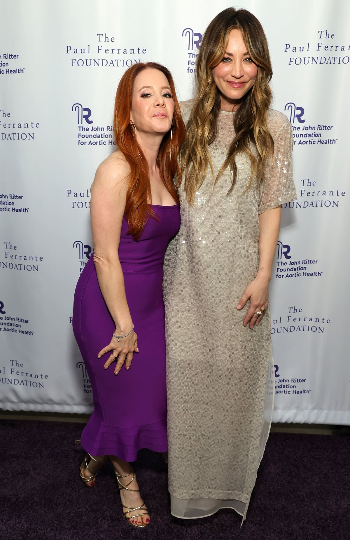 Kaley Cuoco dazzles in a sparkling Brunello Cucinelli floor-length dress, while Amy Davidson stuns in a vibrant purple form-fitting dress at the 2024 Evening From the Heart Gala in Los Angeles